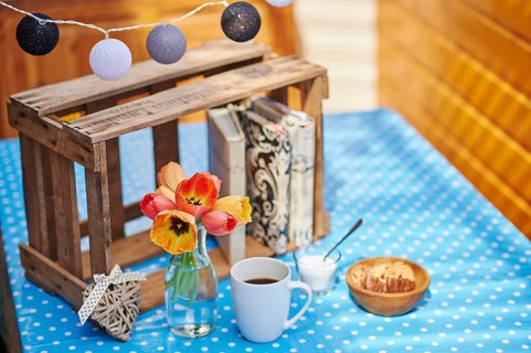 A cup of coffee, sugar, cookies and a vase of blossoms on a table, Germany