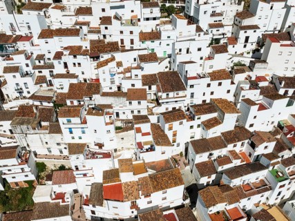 The brilliant White Town of Casares clings to a steep hillside. Aerial view. Drone shot. Málaga