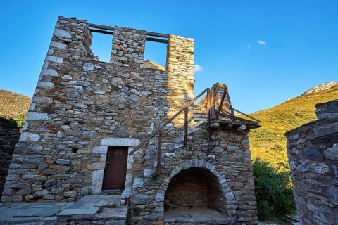 Ruins of a building with arched doorways and detailed stonework, Vathia, residential tower village,