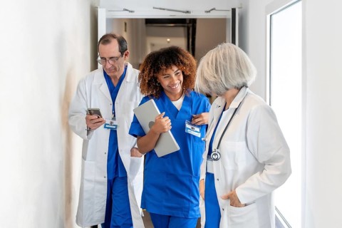 Diverse healthcare team walking a bright hospital corridor, young african american nurse with