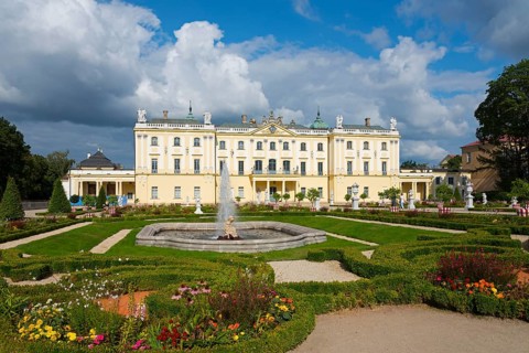 Baroque palace with magnificent flower garden and central fountain under a blue sky, Branicki