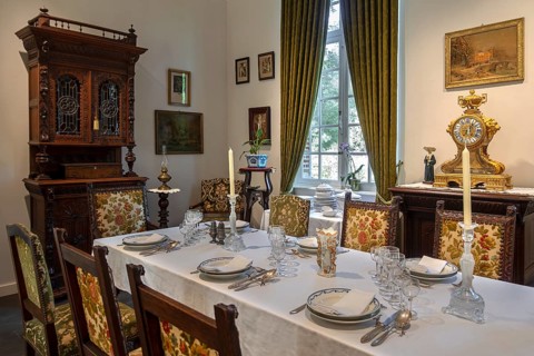 Dinner table with antique tableware in dining room inside 18th century clergy house Schriek at open