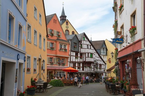 Colourful historic street with half-timbered houses and shops, bustling with people, Bernkastel