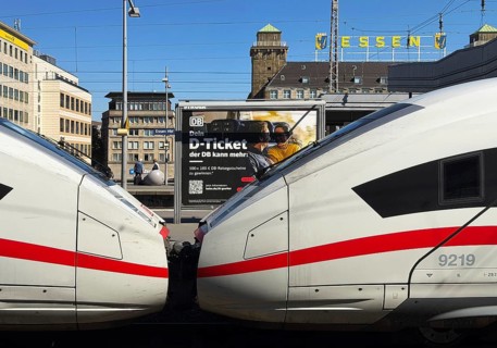 ICE at the main train station with a view of a Deutsche Bahn D-ticket poster and the city center,