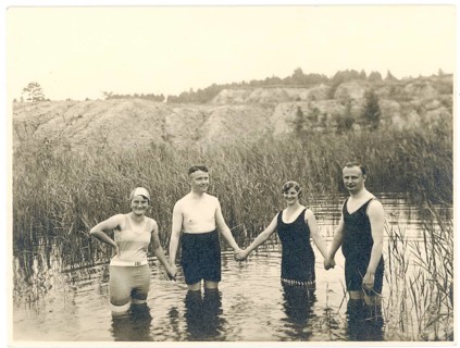 Bathing, swimwear, leisure, summer, woman, men, two couples holding hands in the water of a lake,