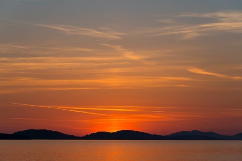 A calm sunset over the sea with orange and red coloured sky, Šibenik, Sibenik, Dalmatia, Croatia