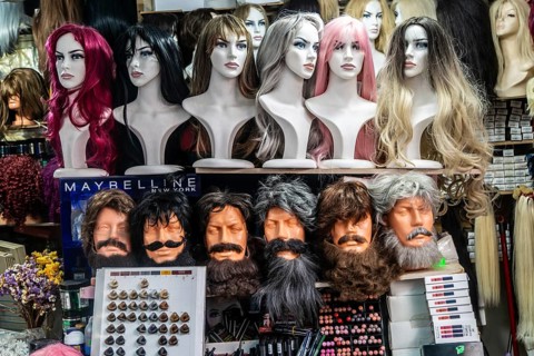Market stall display of mannequin heads with wigs and false beards, Tirana, Albania
