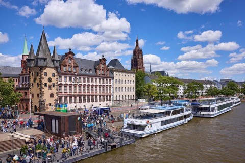 Saalhof with rent tower and excursion boats at the Mainkai under a blue sky with cumulus clouds in