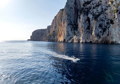 Motorboat rides on picturesque rocky coast ImmorgenLicht, cliffs, Golfo di Orosei, Baunei,