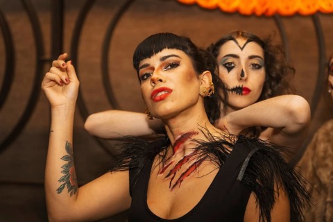 Female friends in costumes at the halloween party with friends in a disco nightclub