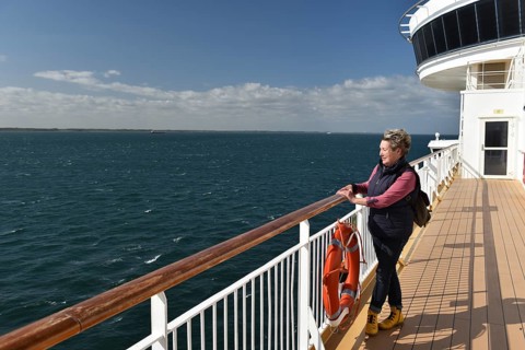 Woman standing at the railing of a ship, ferry in the Baltic Sea