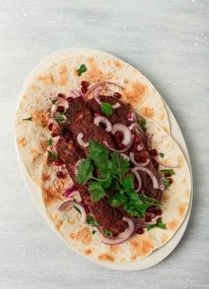 Lula kebab, on lavash, with red onion, pomegranate, and sumac, top view, close-up, horizontal, no