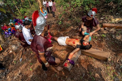 Catholic devotees take part in a re-enact of the crucifixion of Jesus Christ during a Good Friday