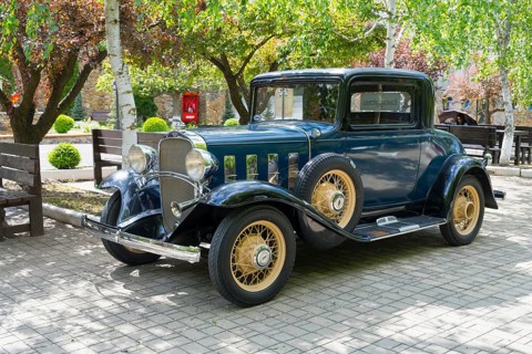 Blue classic car with golden spoked wheels in an autumn parkland, vintage car, Chevrolet