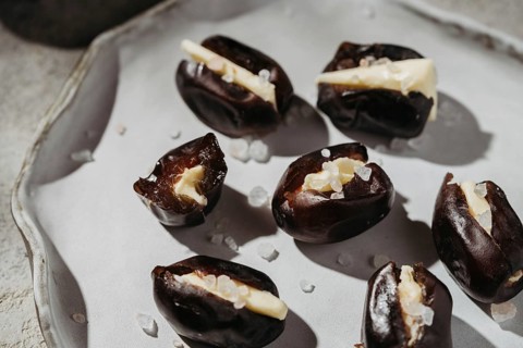 Close-up of plump dates stuffed with smooth butter and sprinkled with coarse sea salt. A delectable