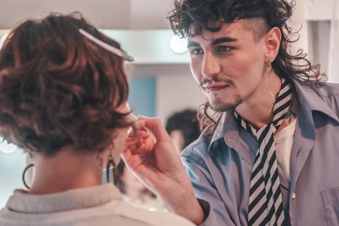 Skilled makeup artist is carefully applying makeup to a model in a professional setting, showcasing