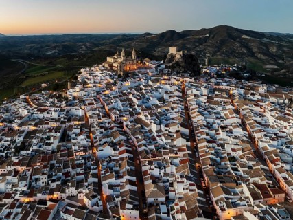 The hilltop White Town of Olvera with its La Encarnación church and Moorish castle. At dusk. Aerial
