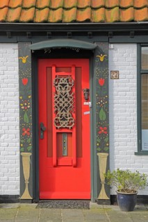 Red front door with frame, decorations and house number, painting, Den Burg, Texel, North Holland,
