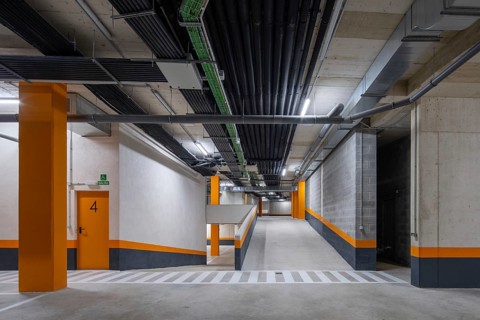 Vibrant and sustainable modern parking garage design featuring bright orange accents and