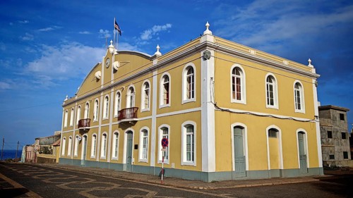 Historic yellow building under blue sky with colonial architecture and Cape Verdean flag, flag,