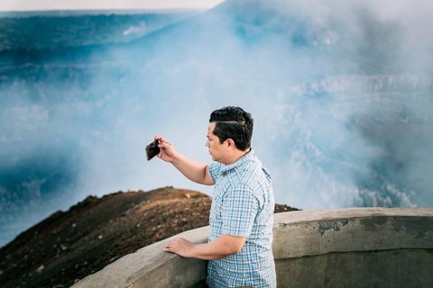 Tourist man taking photos at a viewpoint. Young tourist man taking photos at a volcanic viewpoint.