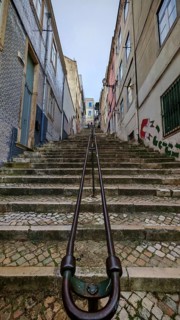 Steep stone staircase in an old town flanked by buildings with small windows, Lisbon, Portugal