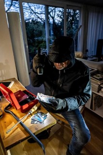 Symbolic image of a burglary, perpetrator has broken into a flat from the garden side and is