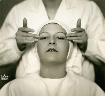 Facial care, woman receiving a facial massage from a second person in a stylized setting, twenties,