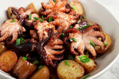 Baby grilled octopus with golden baked potatoes and fresh herbs, Maltese cuisine, homemade, no
