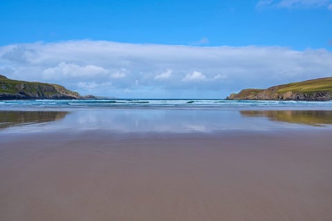 Reflective sandy beach with calm sea and slightly cloudy sky, Farr Bay, Bettyhill, Thurso,