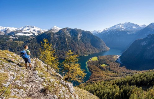 Mountaineer on an exposed mountain hiking trail, Rinnkendlsteig, view of the Königssee, autumnal