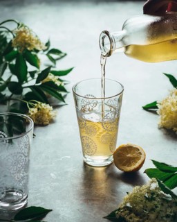 Delight in the fresh salsa flower liqueur being gracefully poured into a patterned glass,