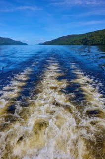 A river with current, wooded hills and a clear blue sky, Fort Augustus, Loch Ness, Scotland, United