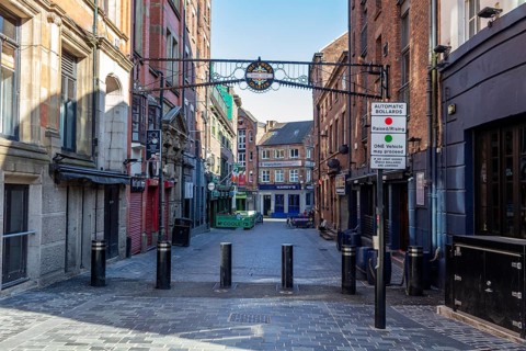 Empty street with brick buildings and a decorative Tor tor on a quiet afternoon, Liverpool