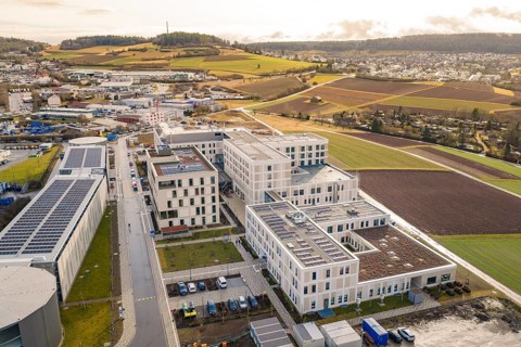 Wide view of a city with modern buildings and green spaces, shortly in front of opening, Calw