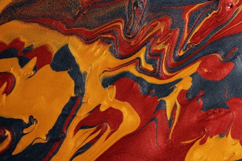 A dynamic abstract background featuring swirling metallic paints, with red, gold, and black colors