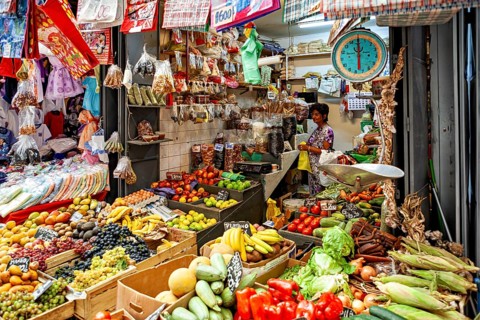 Versatile market stand with fresh fruit and vegetables, saleswoman at work, vivid colors, The