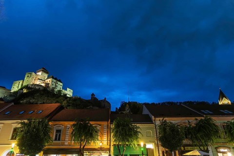 Night shot of the Peace Square in the historic centre of Trencín, Trencín Castle in the background,