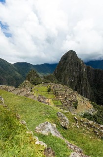Majestic shot of Machu Picchu, with the iconic Huayna Picchu peak in the background under a cloudy
