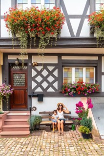 Mother and son sitting in medieval village in old town Gengenbach in Black Forest, Germany, family
