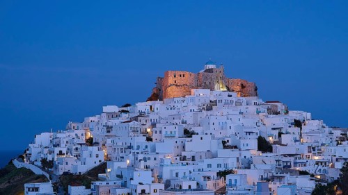 An illuminated castle above a white town at night, Querini Castle, Chora, Astypalea, Dodecanese,