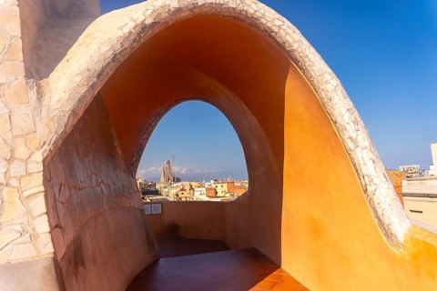 Scenic view of sagrada familia and barcelona cityscape through an architectural arch, capturing the