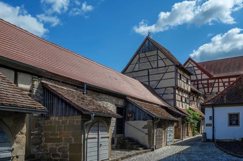 Former storage rooms, barns from the 15th century, in the historic fortified church, Hüttenheim,