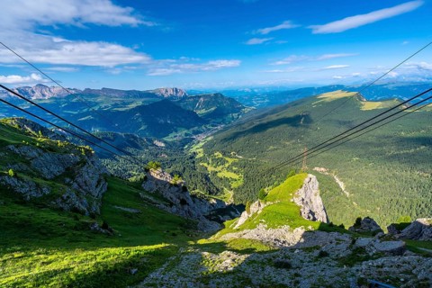 Cable car wires stretching across a breathtaking vista of the seceda mountain range in the