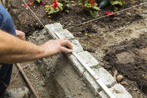 Measuring with a folding rule and thread for the new border of the urn graves, Alleestraße