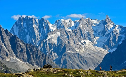 Hikers in the Aiguilles Rouges nature reserve in front of the mighty mountain range of the Grandes