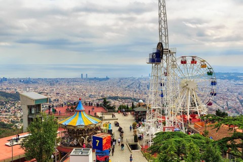 Amusement park, amusement park with Ferris wheel and view of the sea of houses to the coast, cloudy