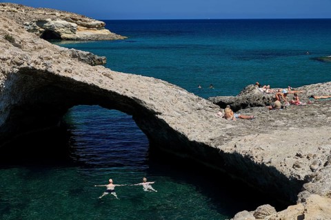 People swim and sunbathe on the rocks of a small bay by the sea, Kapras, Kapros, Beach, Kapros