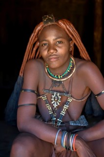 Young Himba woman in her hut, Ohandungu, Kunene region, Kaokoveld, Namibia