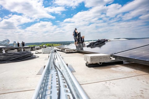 Workers install solar panels on a roof to see sky and distance, PV Assembly, Perrot company, Calw,